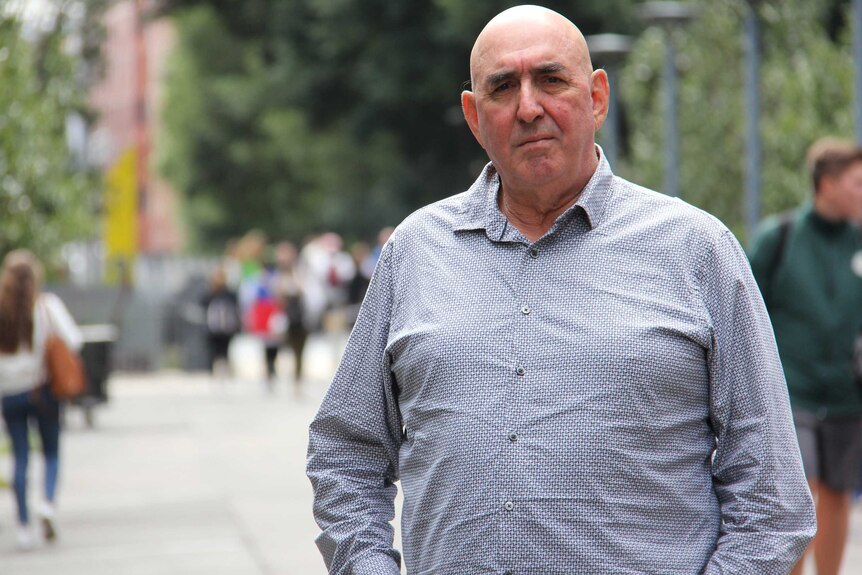 Sydney lawyer Robert Van Aalst stands outside in a pedestrian area.