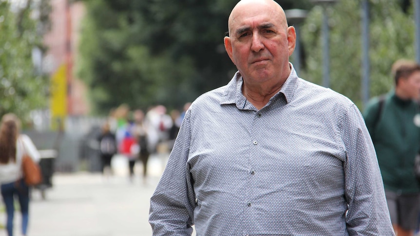 Sydney lawyer Robert Van Aalst stands outside in a pedestrian area.