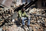 A man sits on rubble after the Nepal earthquake