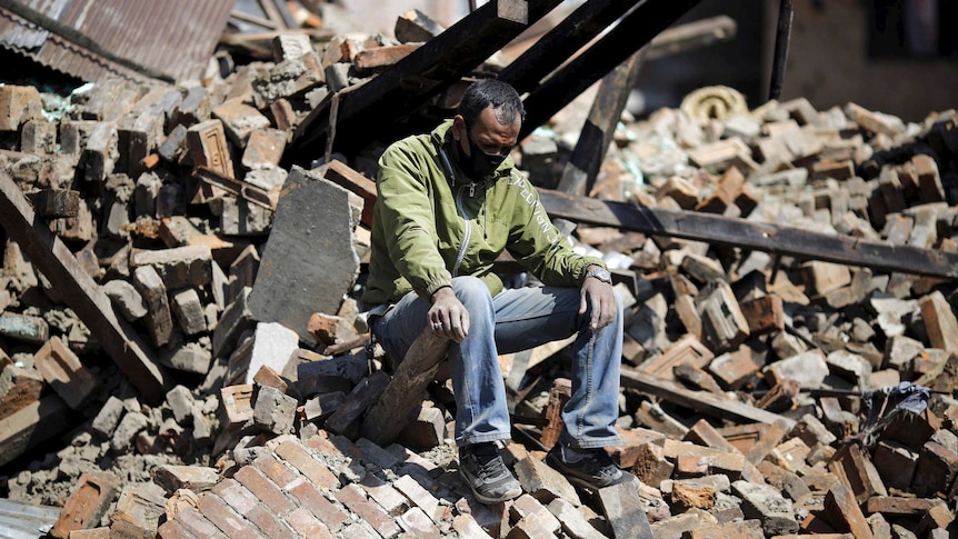 A man sits on rubble after the Nepal earthquake