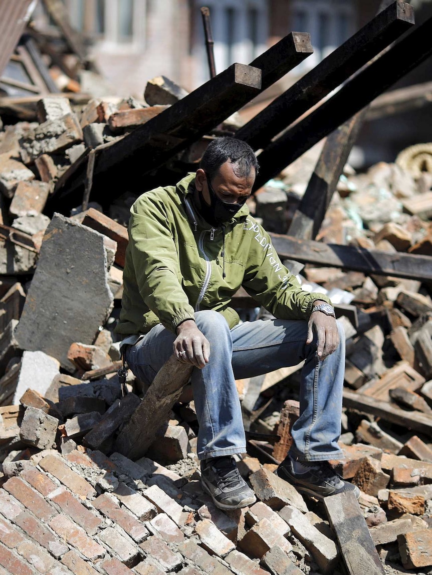 A man sits on rubble after the Nepal earthquake