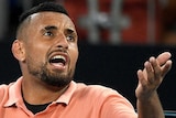 Nick Kyrgios looks up and appears to argue with his hand outstretched