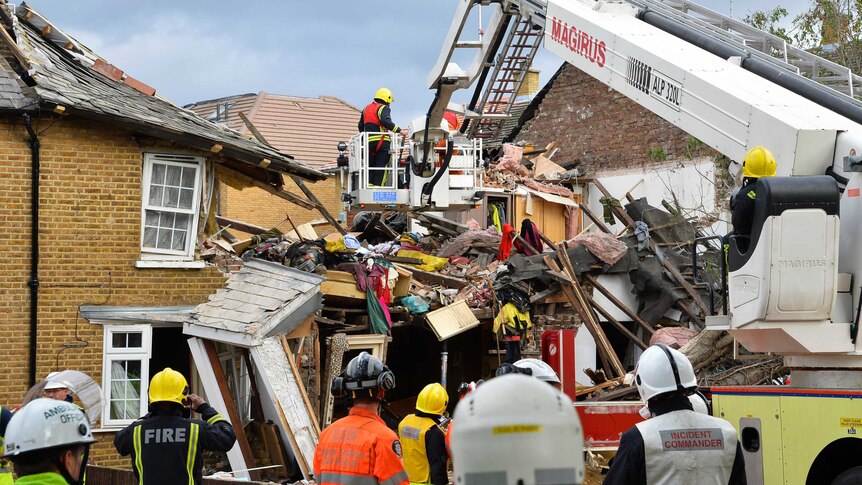 Emergency services work at the scene of a fallen tree on a house in Hounslow, west London.