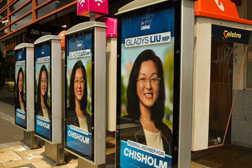 Four posters of Liberal MP Gladys Liu on the back of pay phone boxes in a row