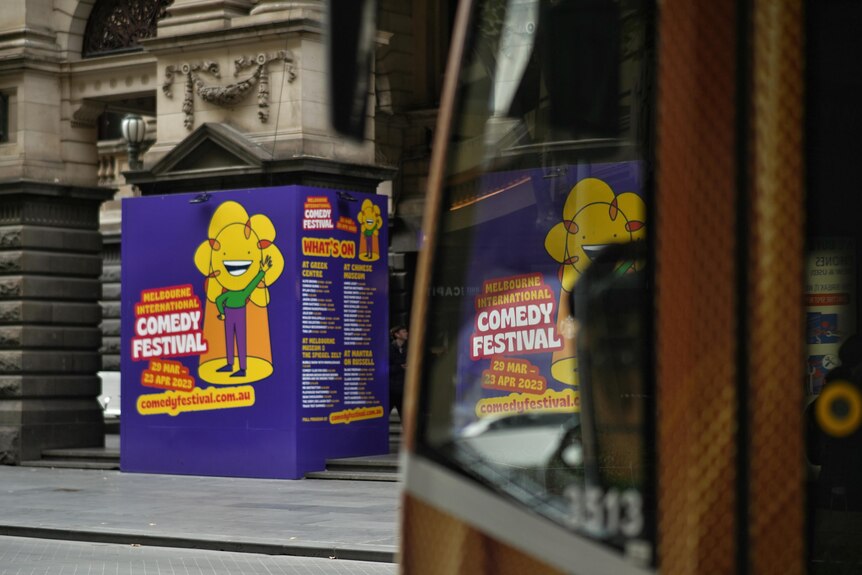 A large sign on the side of the Melbourne Town Hall for the Melbourne International Comedy Festival.