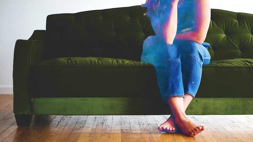 Woman sitting on a green couch looking lonely.