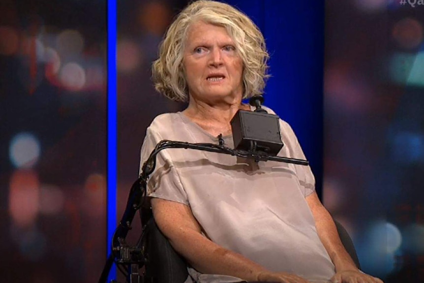 A blonde woman in a wheelchair appearing on a panel program.