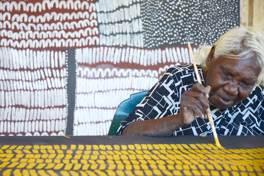 Artist Lena Nyadbi painting at the Warmun Art Centre