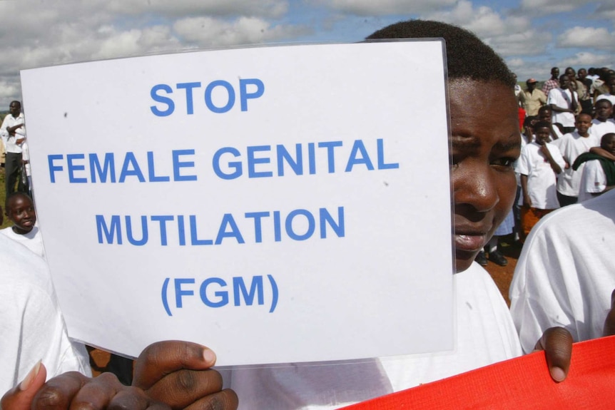 A Masai girl holds a protest sign calling for the ban of female genital mutilation.