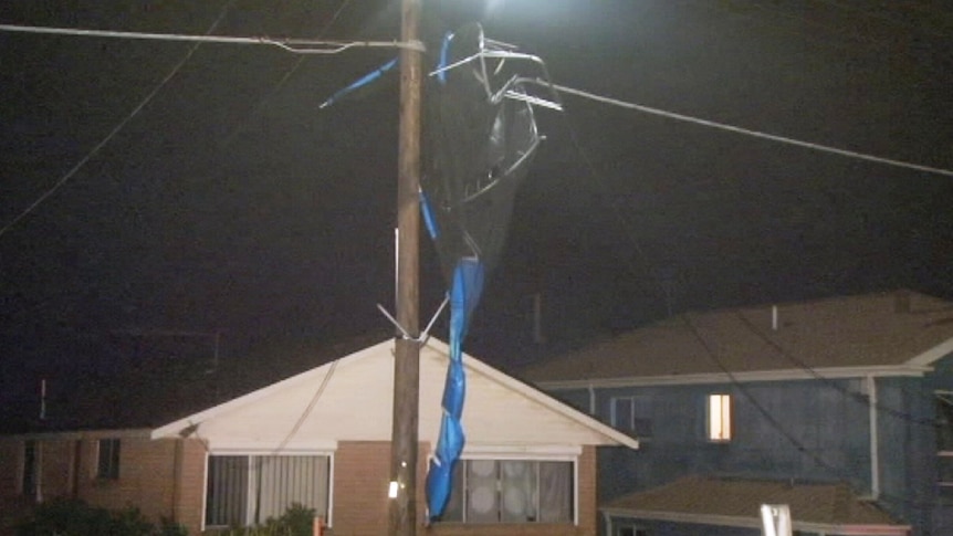 A trampoline is entangled in power lines after storms tore through Sydney suburbs.