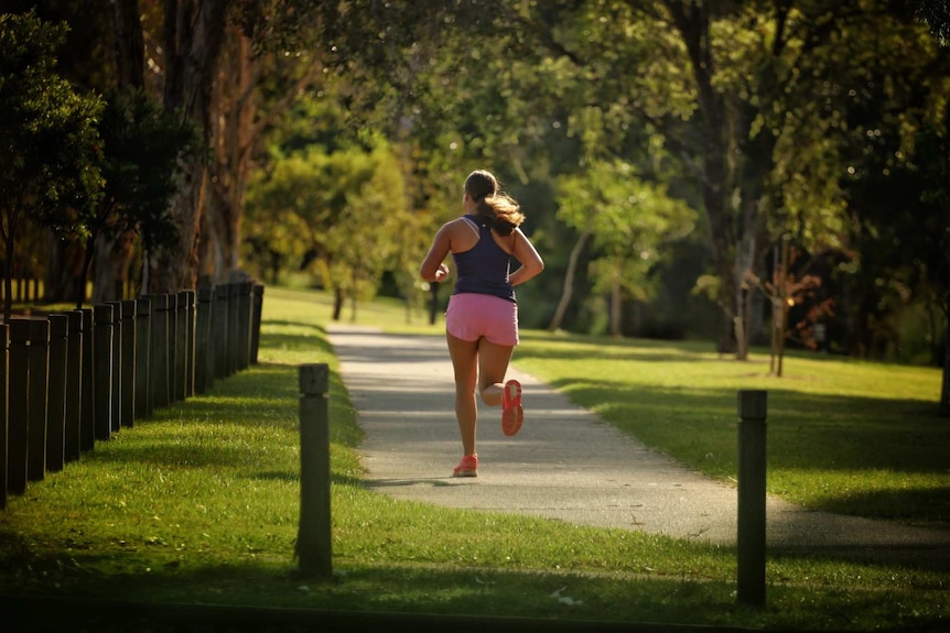 A woman runs along a track.
