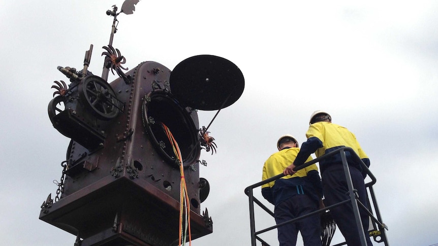 Workmen install the Blumbergville Clock in the Boonah town centre.