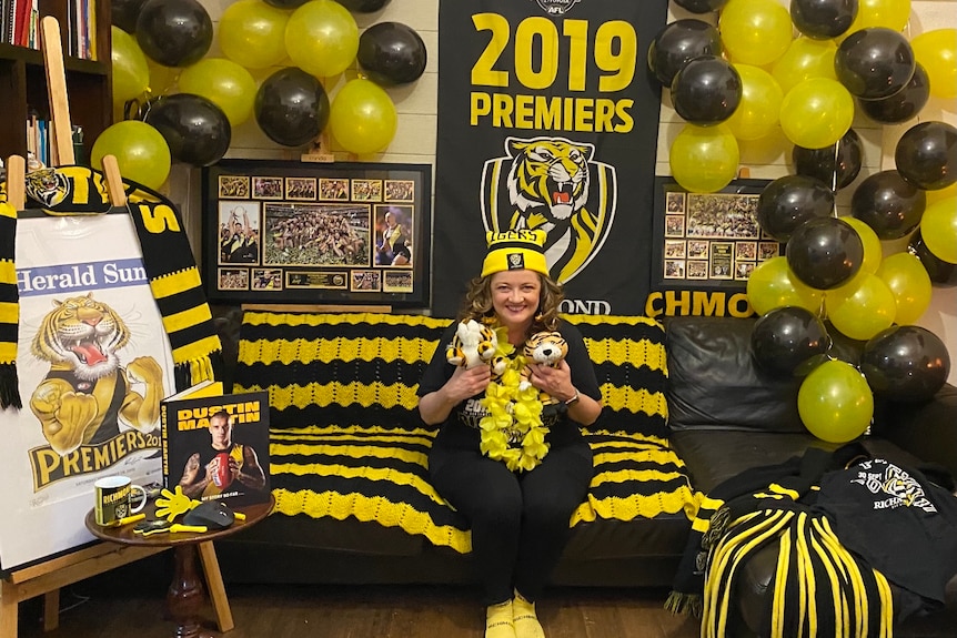 A women seated in a room festooned with Richmond paraphernalia.