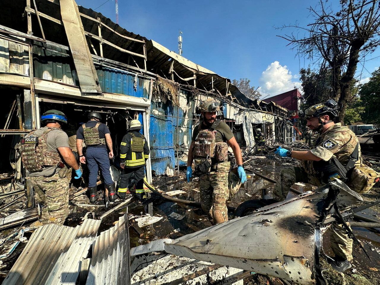 Police officers and rescuers inspect the site of an attack in Ukraine.