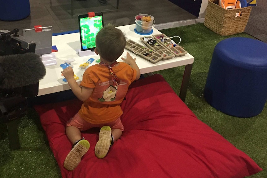 A young boy plays with a tablet device.