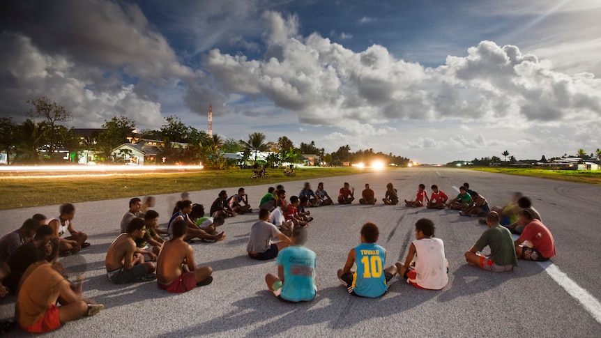 In the late afternoon, people gather and play sport on the airport runway at Funafui in Tuvalu.