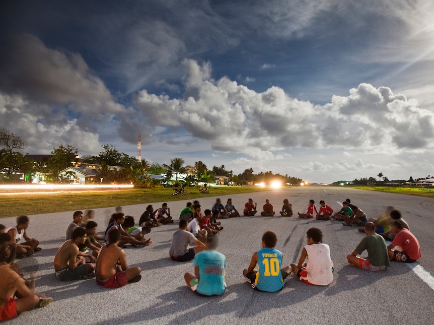 In the late afternoon, people gather and play sport on the airport runway at Funafui in Tuvalu.