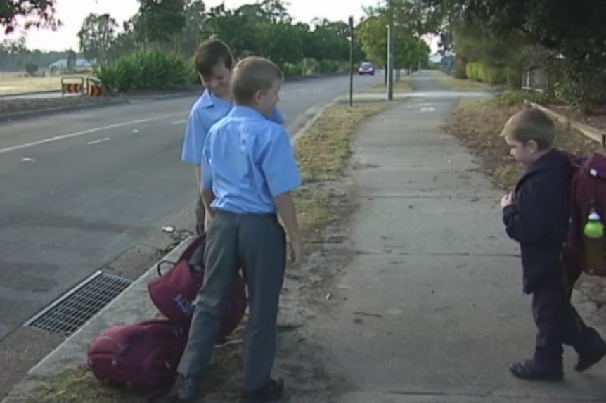 James, Harry and Ted standing on the side of the road with their backpacks.