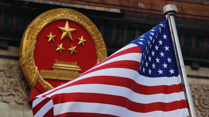 United states flag next to a Chinese emblem