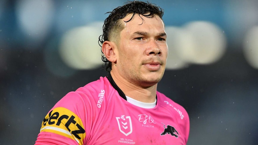 Brent Naden wearing a pink Penrith Panthers jersey looks off screen