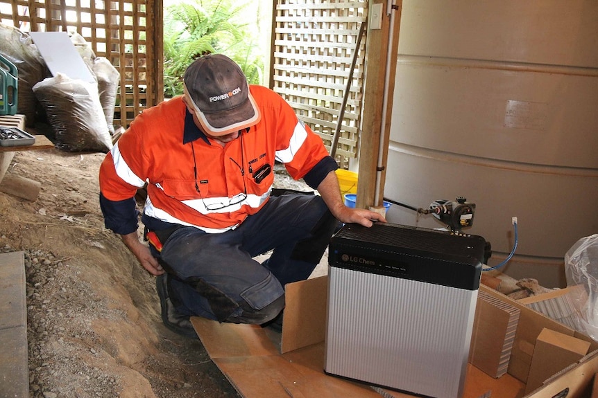 A man inspects a small power supply battery