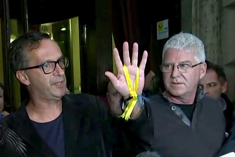 Survivors hold up a yellow ribbon as they speak to the media.