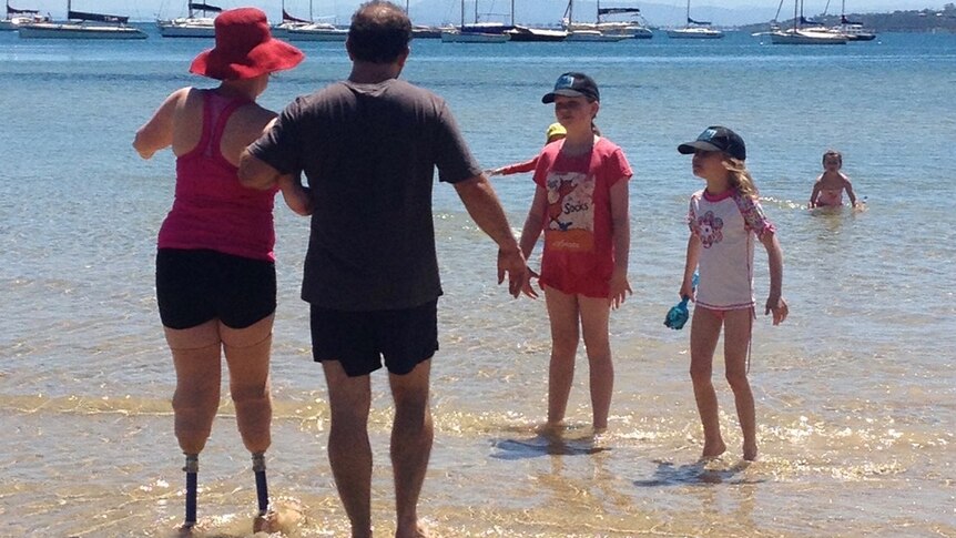 Mandy McCracken with her three children and husband at the beach in story about parenting with a disability