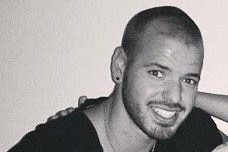 A black and white headshot of a man smiling.