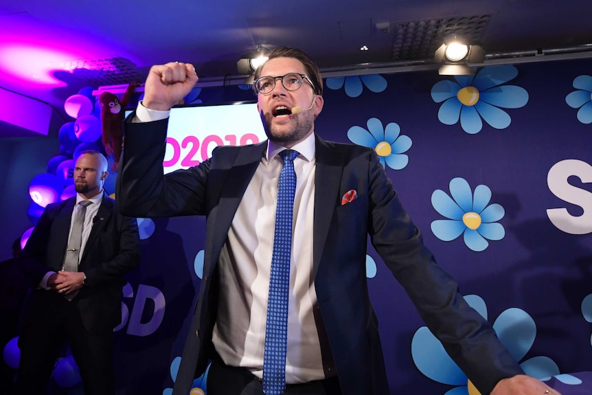 Jimmie Akesson pumps his fist as he speaks at an election party.