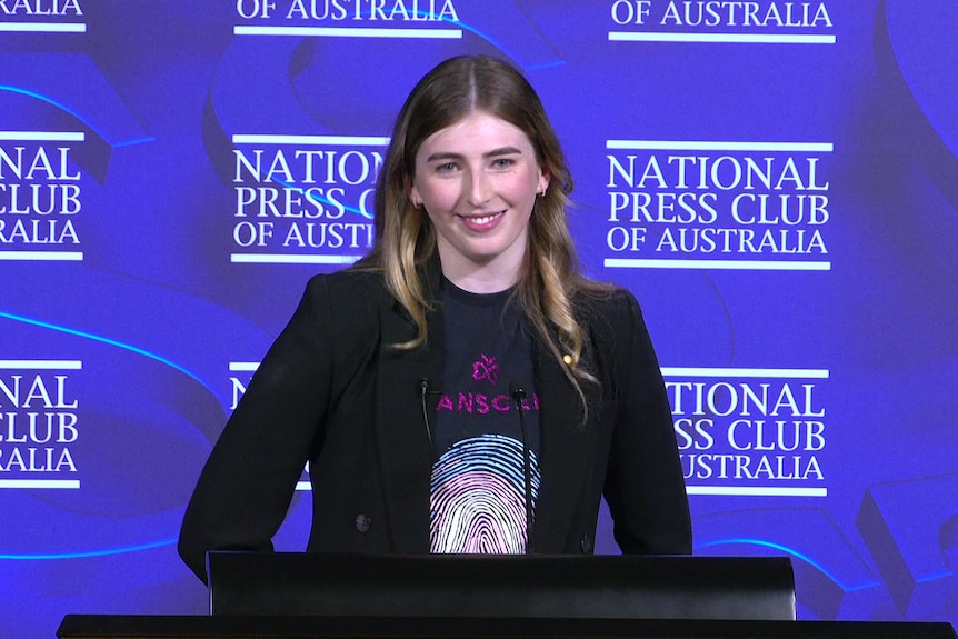 Georgie Stone at the National Press Club standing behind the podium during her speech