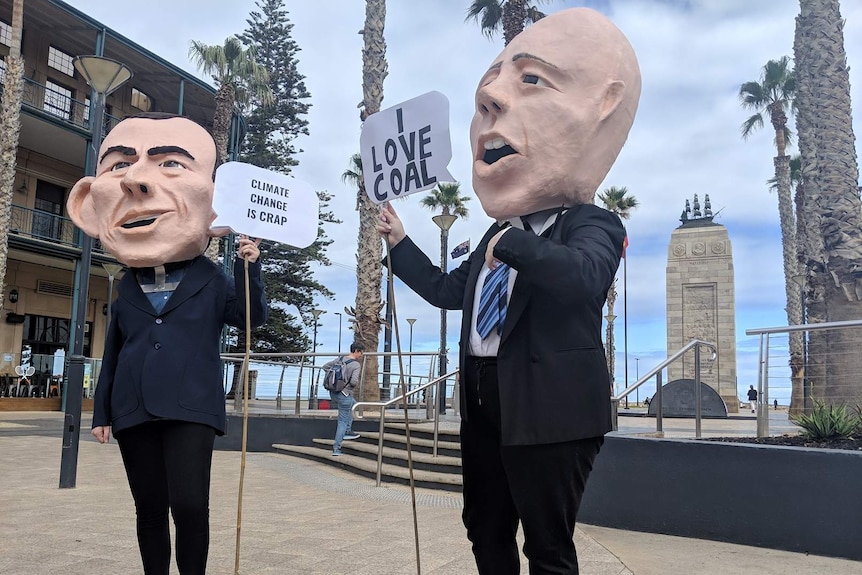 Two people wearing giant heads shaped like Tony Abbott and Peter Dutton