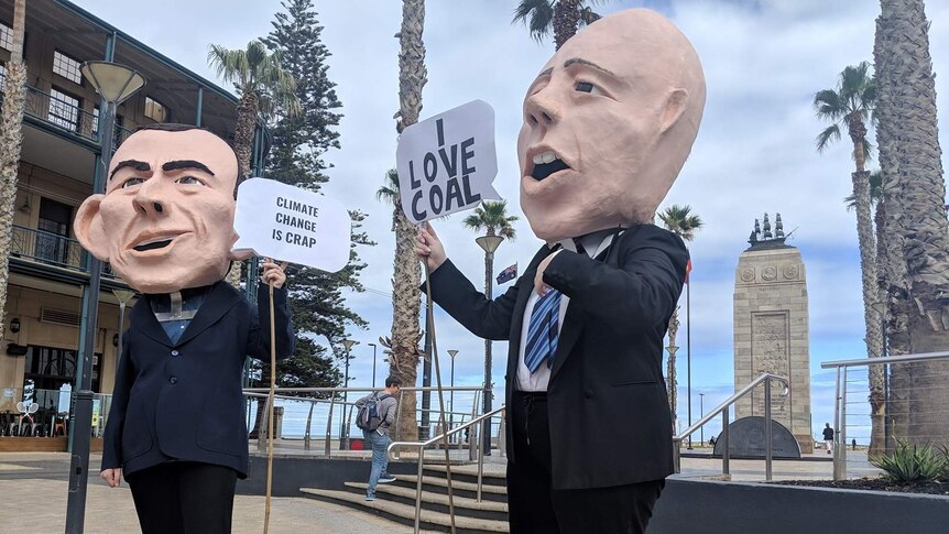 Two people wearing giant heads shaped like Tony Abbott and Peter Dutton