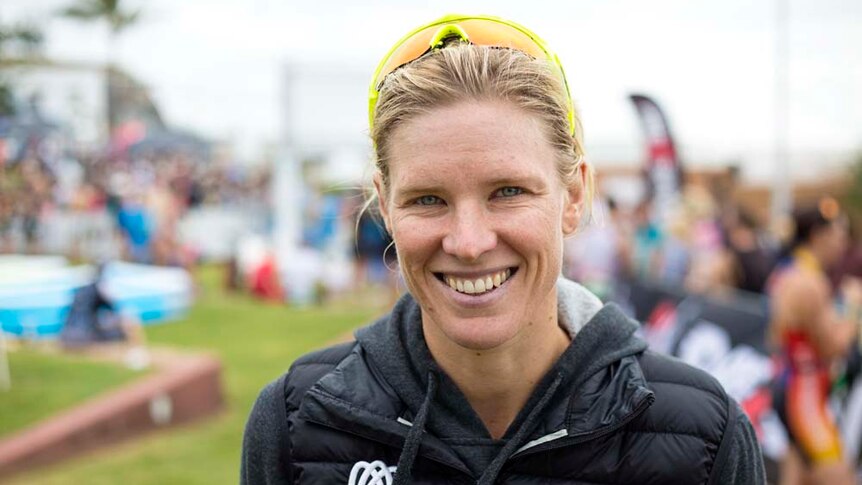 Triathlete Kate Doughty smiles at camera, background blurred