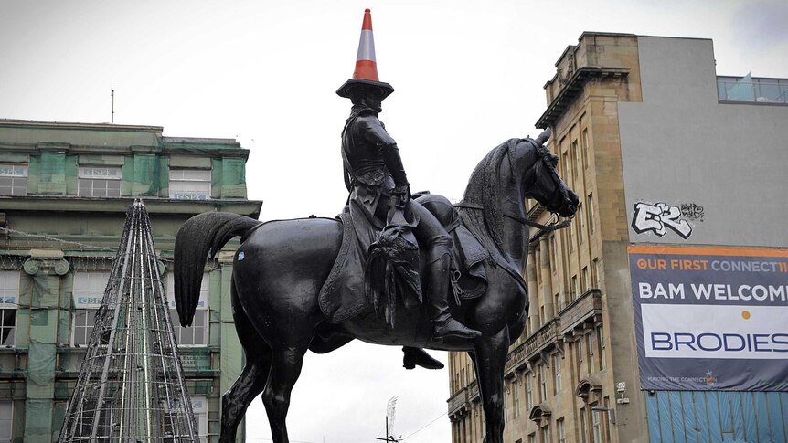 A traffic cone balances on the head of a statue of The Duke of Wellington in central Glasgow.