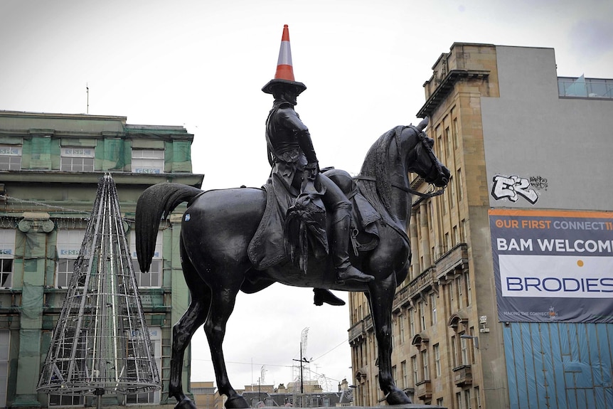 A traffic cone balances on the head of a statue of The Duke of Wellington in central Glasgow.