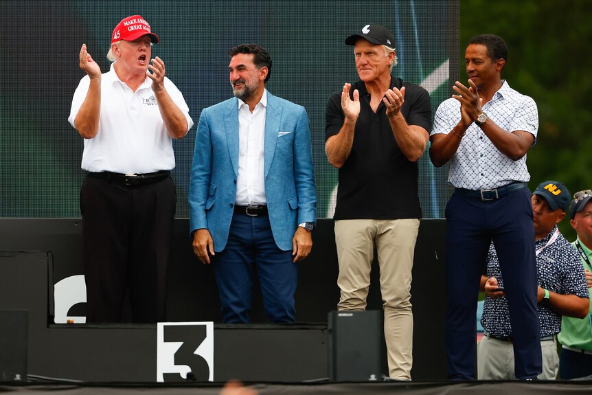 Donald Trump, Yasir Al-Rumayyan, Greg Norman and Majed-al-Sorour applaud on stage at a LIV Golf event.