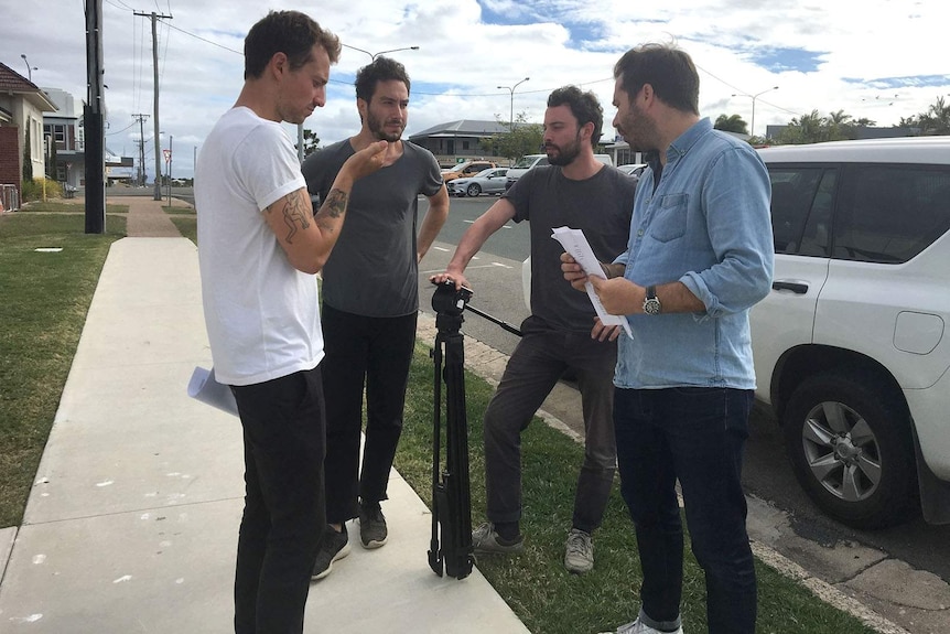 Four men stand on the roadside outside Bowen police station