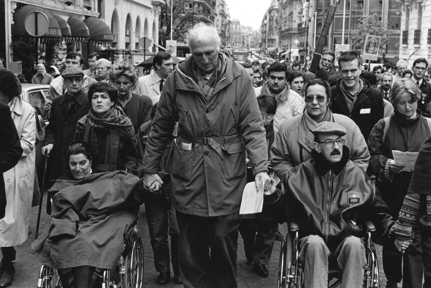 Jean Vanier marching with handicapped persons in 1992