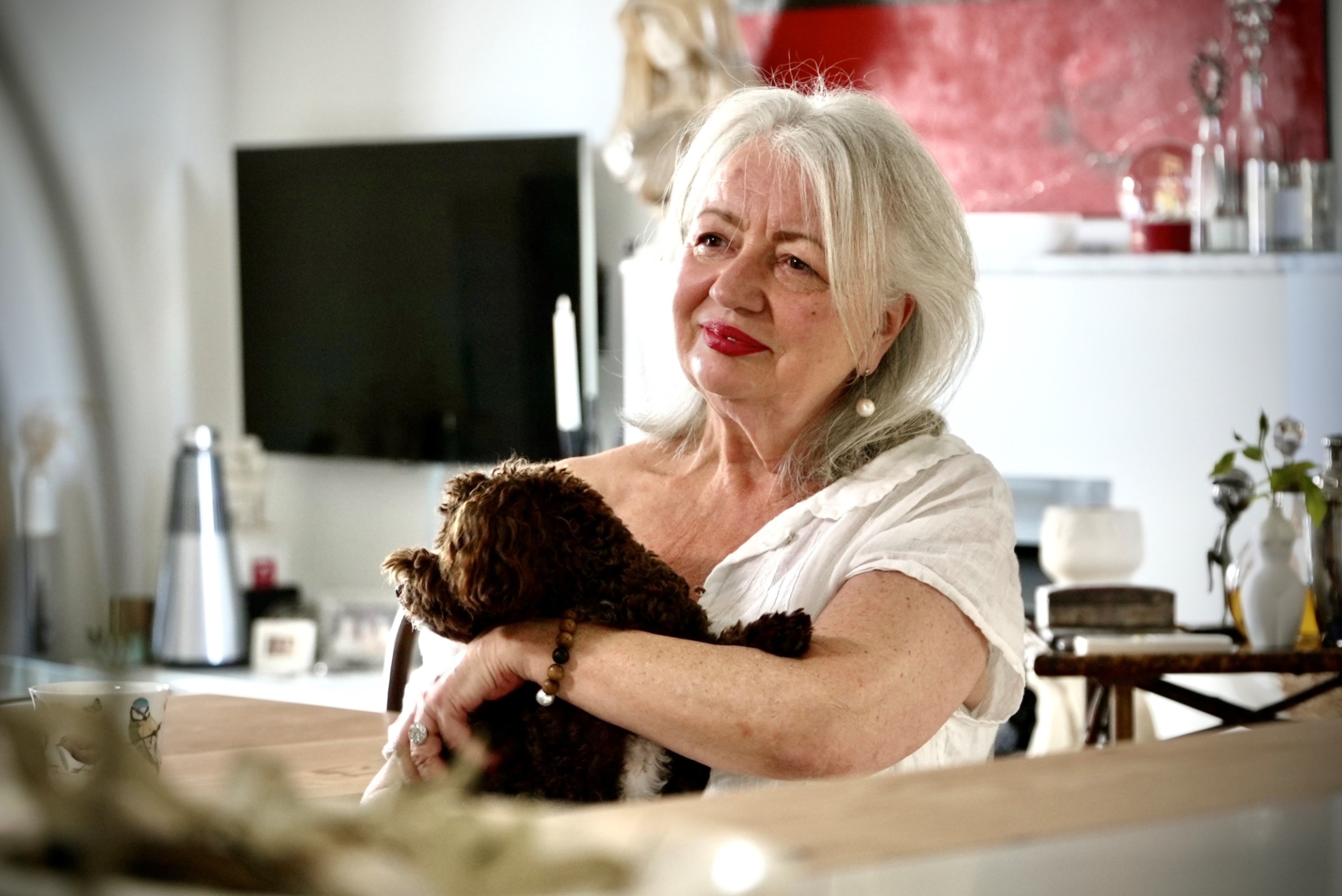 Kerrie sitting with her dog in her Sydney home