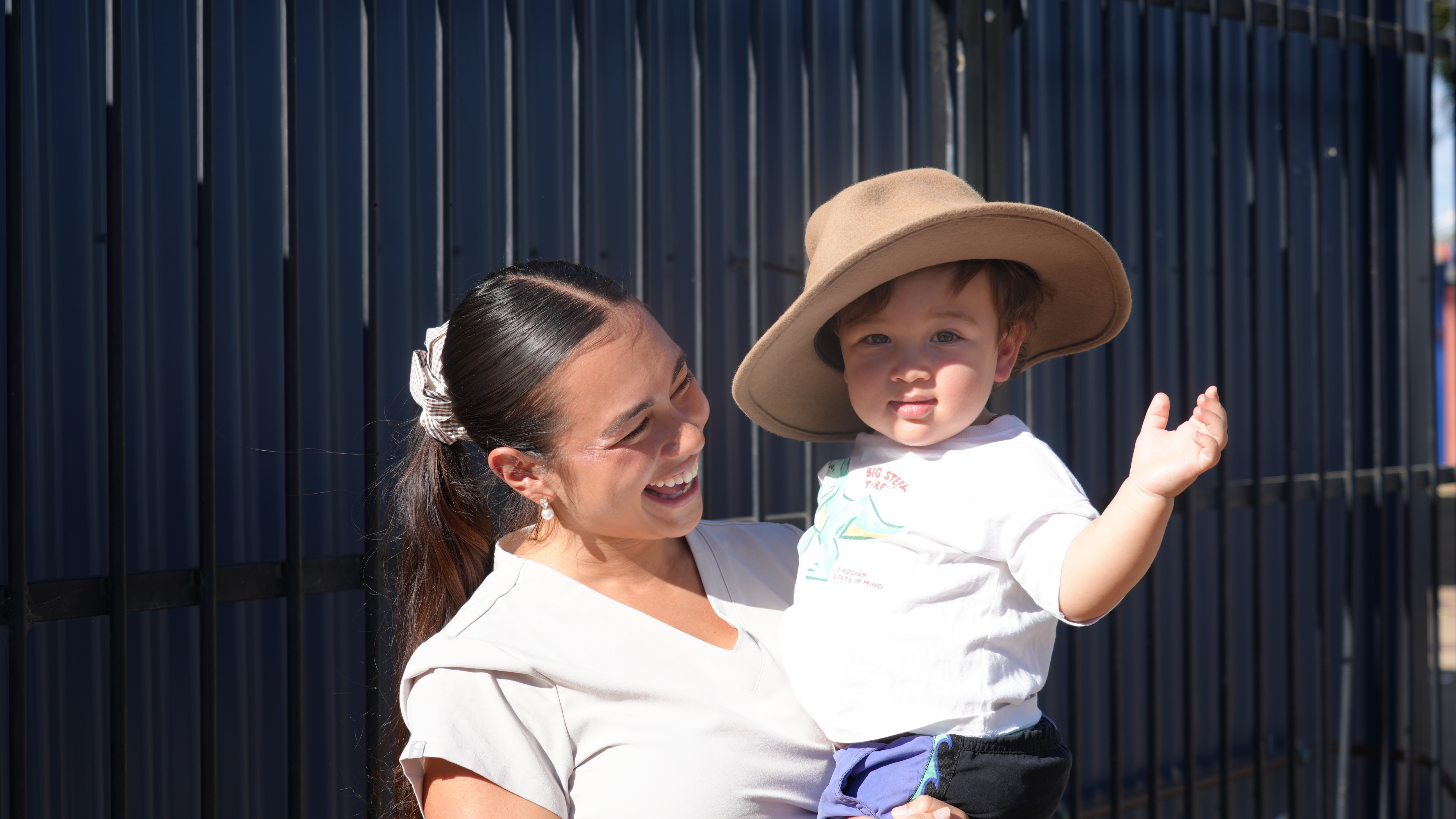 baby thomas ibelli wears an akubra-style hat being held by his smiling mum