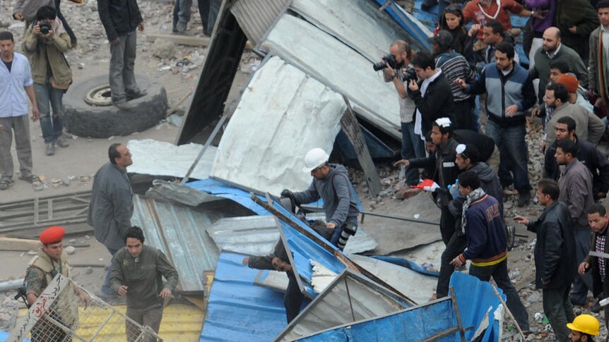 Egyptian army soldiers make their way through a barricade
