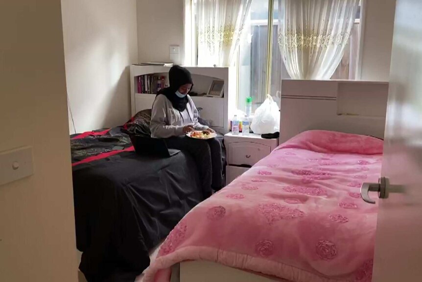 Nahili Osman sits in isolation in her bedroom with her dinner on her lap.