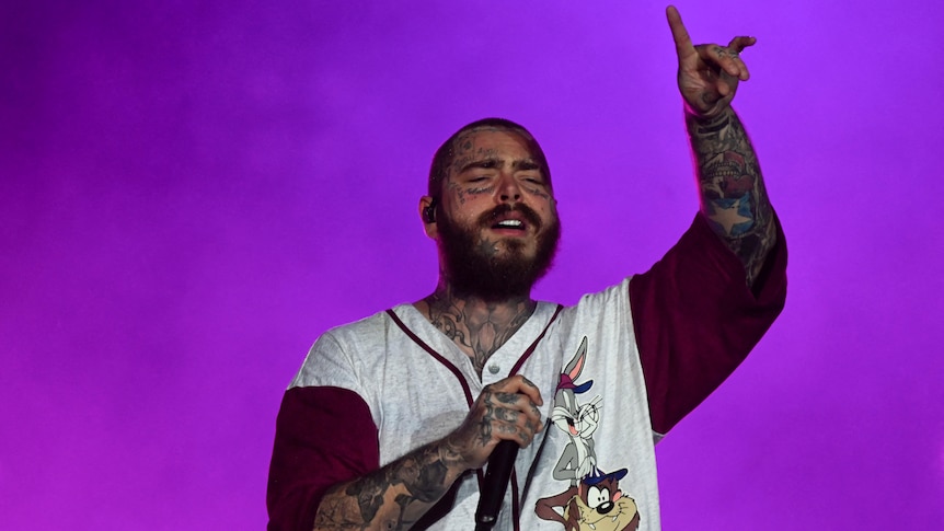 Post Malone performing live at Rock in Rio festival 2022, raising devil's horns with his left hand