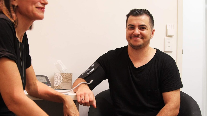 a man being getting a blood pressure test at the doctors