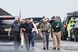 Law enforcement officers gather near the scene where the body of a woman was found in Laredo, Texas.