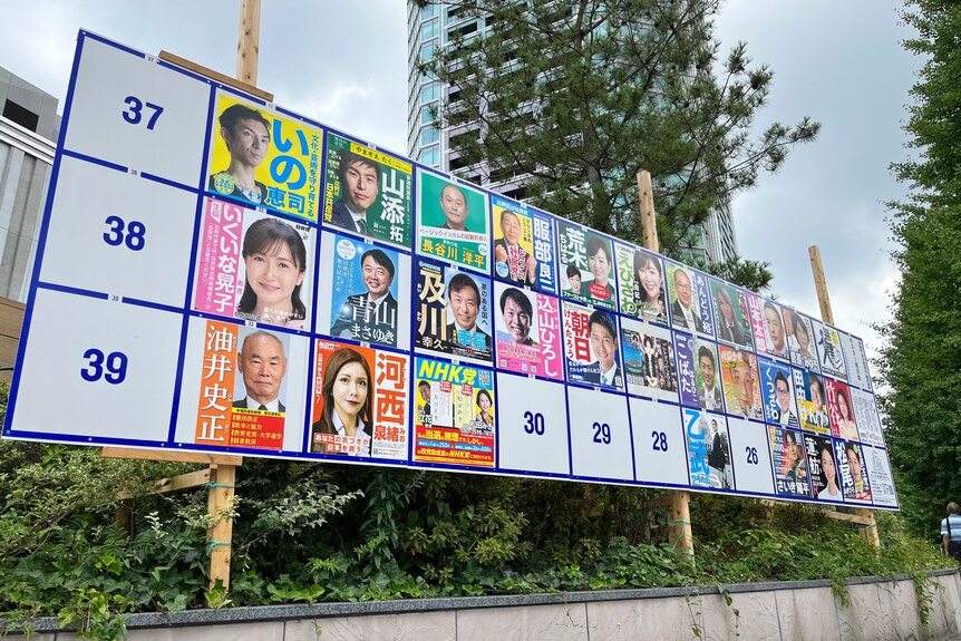 A billboard is broken up into equal squares and candidate photos fill some of them. 