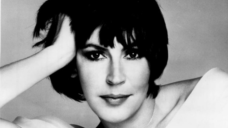 Helen Reddy posers for the camera reclining with one hand in her hair