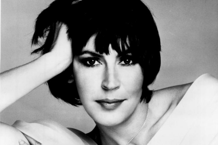 Helen Reddy posers for the camera reclining with one hand in her hair