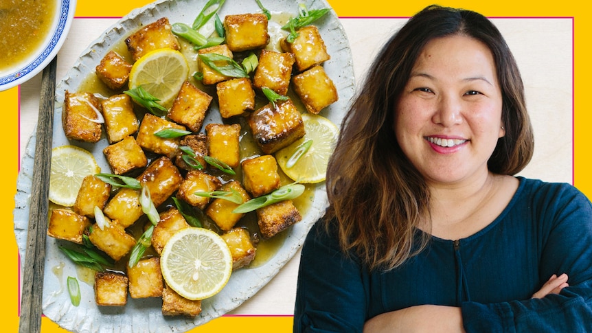 Hetty McKinnon in front of a serving plate of fried tofu covered in a sweet and tangy lemon sauce, a vegetarian recipe.