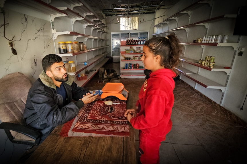A girl talks to a shopkeeper at a desk